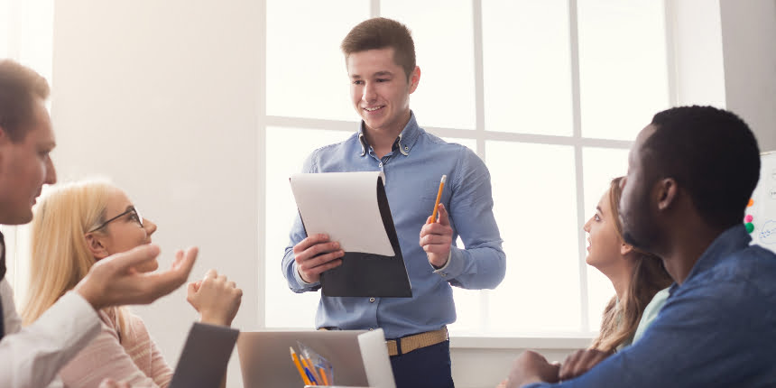 Treinamento on the job: homem fazendo uma apresentação para quatro colegas de trabalho